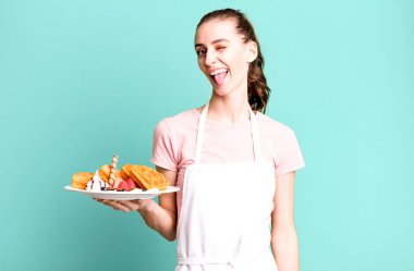 Neşeli ve asi tavırları olan genç ve güzel bir kadın, şaka yapıyor ve dilini dışarı çıkarıyor. Waffle konsepti