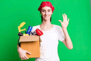 young pretty woman smiling and looking friendly, showing number five. housekeeper and toolbox concept