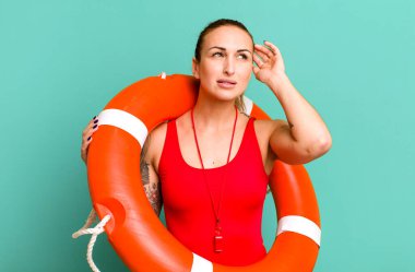 Genç ve güzel bir kadın mutlu bir şekilde gülümsüyor ve hayal kuruyor ya da şüphe ediyor. yaz ve cankurtaran konsepti