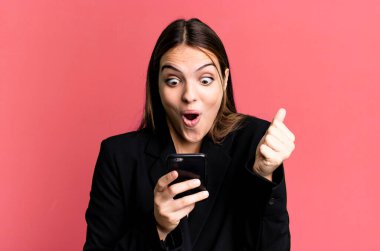 Genç ve güzel iş kadını akıllı telefonunu kullanıyor.