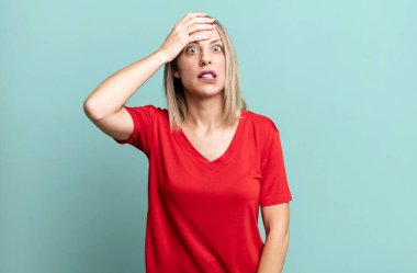 blonde adult woman panicking over a forgotten deadline, feeling stressed, having to cover up a mess or mistake