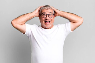 Orta yaşlı bir adam mutlu, kaygısız, arkadaş canlısı ve rahat görünüyor hayattan ve başarıdan keyif alıyor, olumlu bir tavırla.