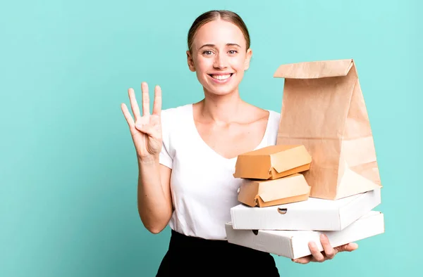 Kaukasische Mooie Vrouw Glimlachend Vriendelijk Toont Nummer Vier Met Fastfoodpakketten — Stockfoto