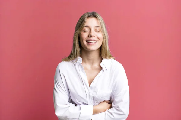 stock image blonde pretty woman laughing out loud at some hilarious joke, feeling happy and cheerful, having fun