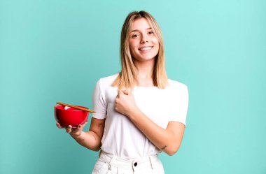 young pretty woman feeling happy and facing a challenge or celebrating. japanese ramen noodles concept