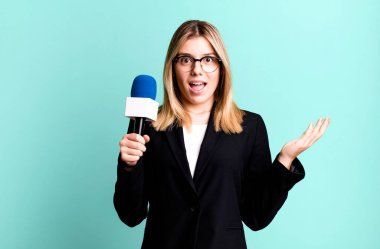 Genç ve güzel bir kadın inanılmaz bir şey karşısında kendini mutlu ve şaşkın hissediyor. sunucu veya gazeteci kavramı