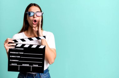 Genç, güzel bir kadın kendini mutlu hissediyor. Elleri ağzının kenarında bağırıyor. Sinema filmi veya film konsepti