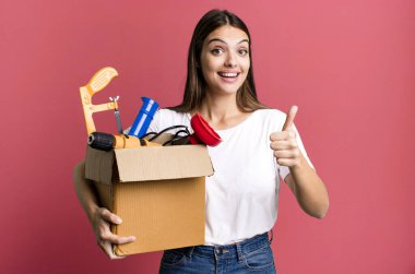 young pretty woman feeling proud,smiling positively with thumbs up. housekeeper concept