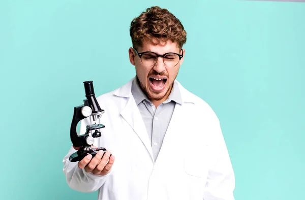 코카서스 남자가 공격적으로 소리치며 표정을 있습니다 현미경 개념을 실험실 학생들에게 — 스톡 사진