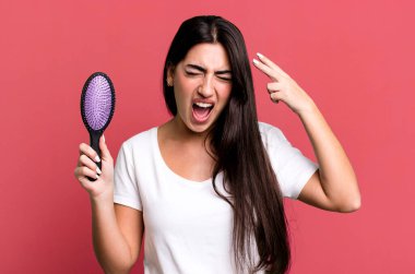 Mutsuz ve stresli görünüyor, intihar jesti silah işareti yapıyor. saç tarağı konsepti