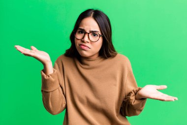 İspanyol güzel kadın şaşkın, şaşkın ve stresli görünüyor, farklı seçenekler arasında merak ediyor, kararsız hissediyor