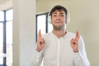 Genç yakışıklı adam şans diliyor ve şans diliyor. kulaklıkla müzik dinlemek