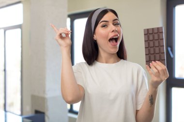 Güzel genç bir kadın bir fikri fark ettikten sonra mutlu ve heyecanlı bir dahi gibi hissediyor. çikolata kavramı