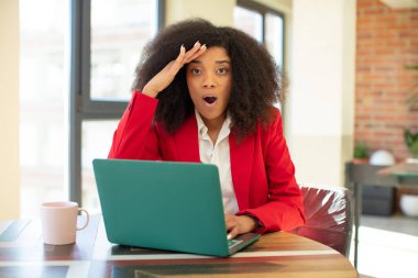 Oldukça afro siyah bir kadın mutlu, şaşkın ve şaşırmış görünüyor. iş kadını ve dizüstü bilgisayar konsepti