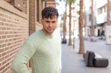 Genç yakışıklı, gururlu, kendine güvenen, havalı, küstah ve kibirli görünen, başarılı hisseden bir adam.