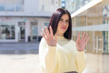 Genç ve güzel bir kadın, tiksinmiş ve rahatsız olmuş hissediyor. Dilini dışarı çıkarıyor, iğrenç ve iğrenç bir şeyden hoşlanmıyor.