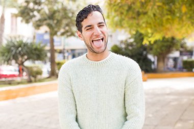 Neşeli, kaygısız, asi tavırlı, şakacı ve dilsiz genç bir adam, eğleniyor.