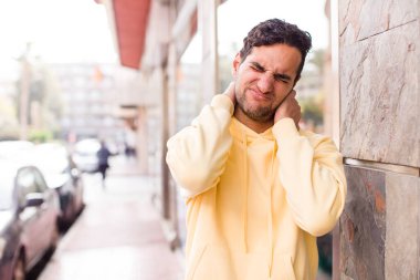 Genç İspanyol bir adam endişeli, hasta, hasta ve mutsuz hissediyor. Ağrılı bir boyun ağrısı çekiyor.