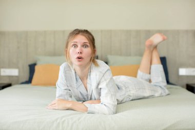 Genç ve güzel bir kadın şok olmuş ve şaşırmış hissediyor. gece kıyafeti konsepti