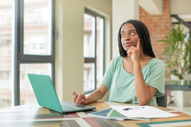 Siyah afro kadın mutlu, kendine güvenen, elleri çenesinde gülümsüyor. öğrenim kavramı