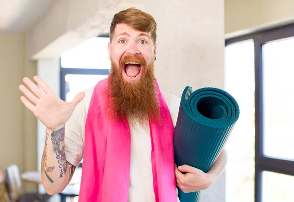 红头发的男人对瑜伽垫令人难以置信的东西感到开心和惊讶 健身概念 — 图库照片