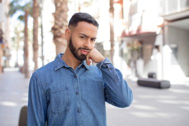 Genç yakışıklı adam üzgün ve stresli, kötü bir sürpriz yüzünden üzgün, olumsuz, endişeli bir bakışla