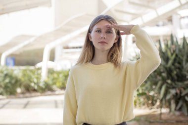 Güzel genç bir kadın, saygı göstererek, onur ve vatanseverlik adına kameraya askeri bir selamlama yapıyor.