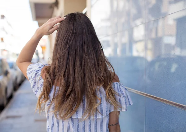 stock image pretty woman thinking or doubting, scratching head, feeling puzzled and confused, back or rear view