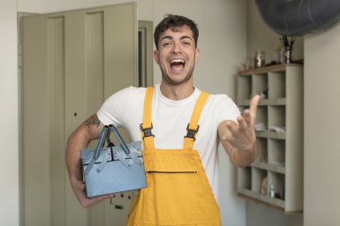 Genç yakışıklı adam mutlu bir şekilde gülümsüyor ve bir konsept sunuyor ya da gösteriyor. Becerikli adam kavramı