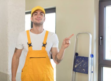 Genç yakışıklı adam neşeyle gülümsüyor, mutlu hissediyor ve bir tarafı işaret ediyor. Becerikli adam kavramı