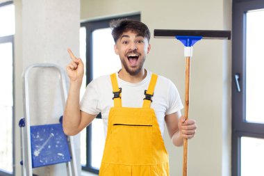 Genç yakışıklı bir adam bir fikri fark ettikten sonra mutlu ve heyecanlı bir dahi gibi hissediyor. pencere temizleme konsepti