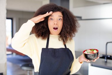 Oldukça afro siyah bir kadın mutlu, şaşkın ve şaşırmış görünüyor. Japon eriştesi kavramı.