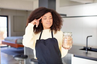 Oldukça afro siyahi bir kadın şaşırmış görünüyor, yeni bir düşünce, fikir ya da konsept fark ediyor. Ev yapımı kurabiye konsepti