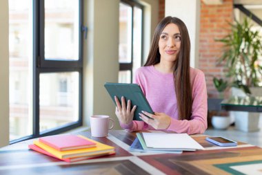 Mutlu ve kendinden emin bir ifadeyle gülümsüyor. üniversite öğrencisi ve not defteri