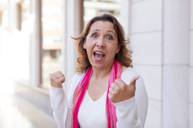 Orta yaşlı bir kadın neşeyle gülümsüyor ve mutlu görünüyor, kaygısız ve pozitif hissediyor.