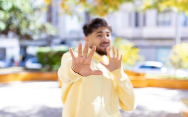 Dehşete kapılmış genç yakışıklı bir adam korku ve panik içinde geri çekiliyor ve bir kabusa tepki veriyor.