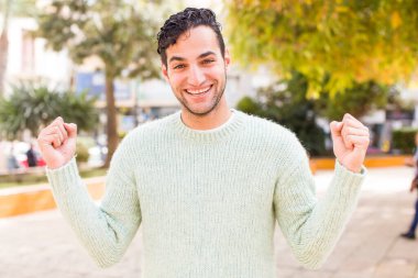 Genç İspanyol adam şok olmuş, heyecanlı ve mutlu hissediyor, gülüyor ve başarıyı kutluyor,!