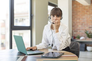 Genç, güzel bir kadın korkmuş, endişeli ya da kızgın hissediyor ve yan tarafa bakıyor. tele pazarlamacı kavramı