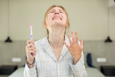 Genç ve güzel bir kadın ellerini havaya kaldırarak çığlık atıyor. diş yıkama kavramı