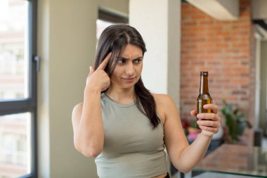Genç kadın şaşırmış görünüyor, yeni bir düşünce, fikir ya da konsept fark ediyor. bira şişesi