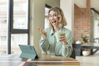 Güzel bir kadın mutlu bir şekilde gülümser ve bir konsept sunar ya da gösterir. dokunmatik ekran konsepti