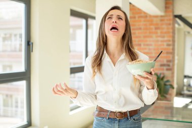 Güzel bir kadın ellerini havaya kaldırarak çığlık atıyor. Kahvaltı kasesi konsepti