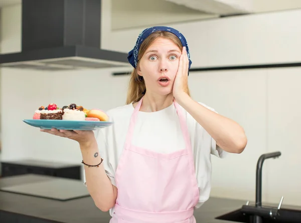 Young Pretty Woman Feeling Extremely Shocked Surprised Home Made Cakes — Stockfoto