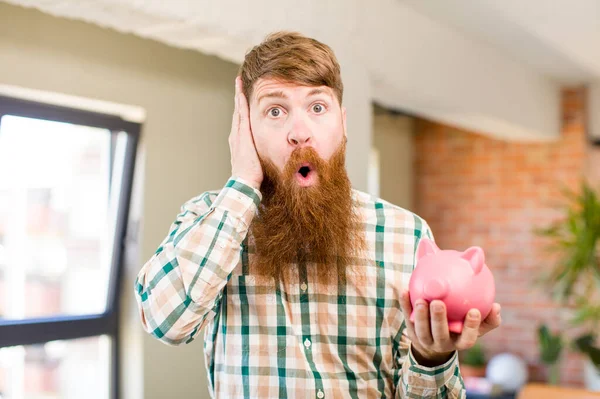 Red Hair Man Feeling Extremely Shocked Surprised Piggy Bank — Stock Photo, Image