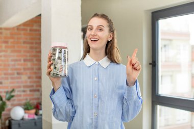 Neşeli bir şekilde gülümsüyor, mutlu hissediyor ve bir tarafı işaret ediyor. Dolar banknotları konsepti