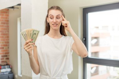 Şaşırmış görünüyor, yeni bir düşünce, fikir ya da konseptin farkına varıyor. Dolar banknotları konsepti