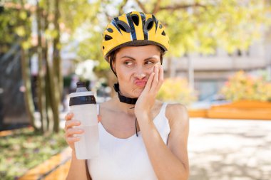 young pretty woman feeling bored, frustrated and sleepy after a tiresome. bike helmet concept