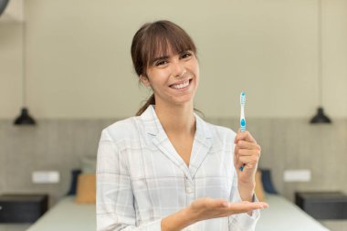 Genç, güzel bir kadın neşeyle gülümsüyor, mutlu hissediyor ve bir konsept gösteriyor. gargara konsepti