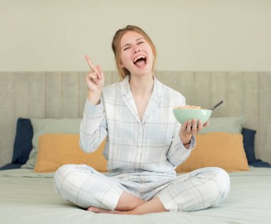 Genç ve güzel bir kadın bir fikri fark ettikten sonra mutlu ve heyecanlı bir dahi gibi hissediyor. Kahvaltı kasesi konsepti