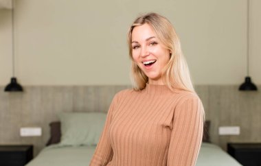 Genç, güzel bir kadın, büyük, dost canlısı, kaygısız bir gülümsemesi var, pozitif, rahat ve mutlu görünüyor, ürpertici. yatak konsepti